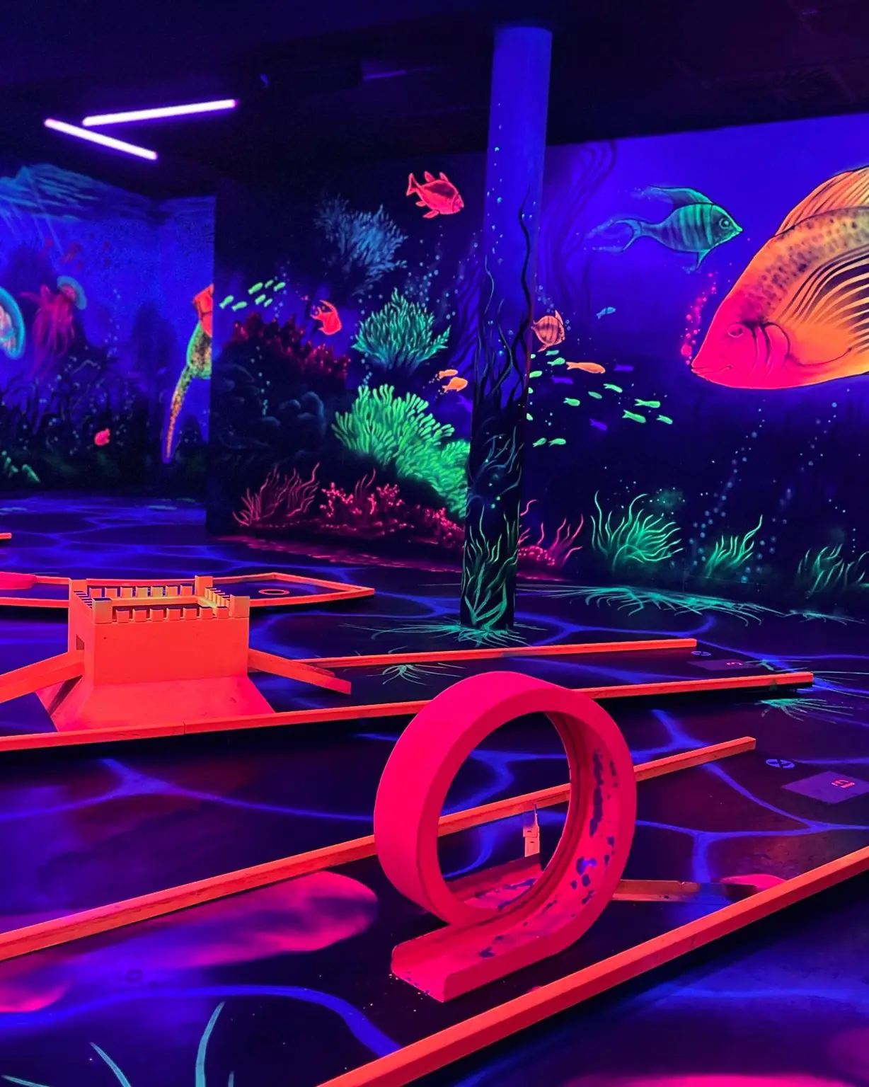 Unterwasserwelt: Minigolfbahn mit Looping unter einem leuchtenden Fisch